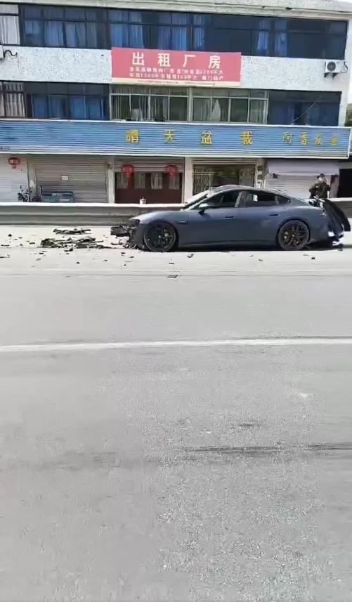 一辆灰色小米SU7电动轿车在浙江绍兴104国道上行驶时，遭受严重的贯穿式损坏，在