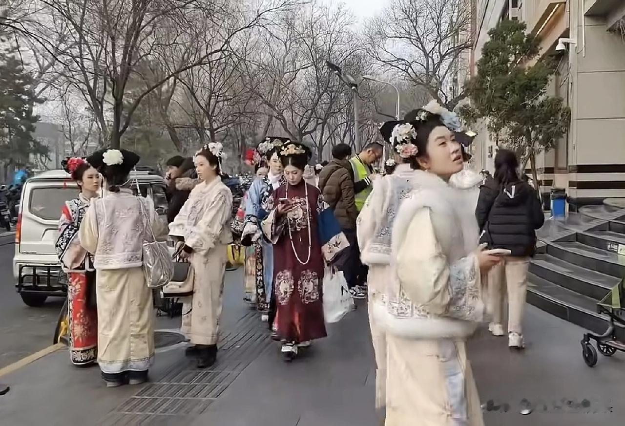 网友拍摄到北京大街上一大堆穿着清朝格格和皇上妃子服装的人，不知道她们是拍戏表演还