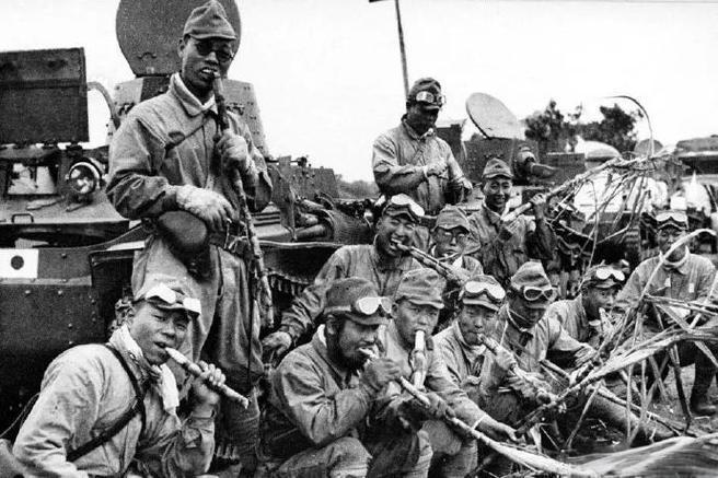 1939年，日军侵占海南三亚后，一群身着军装、沾着征尘的日军士兵，或倚靠着印有日