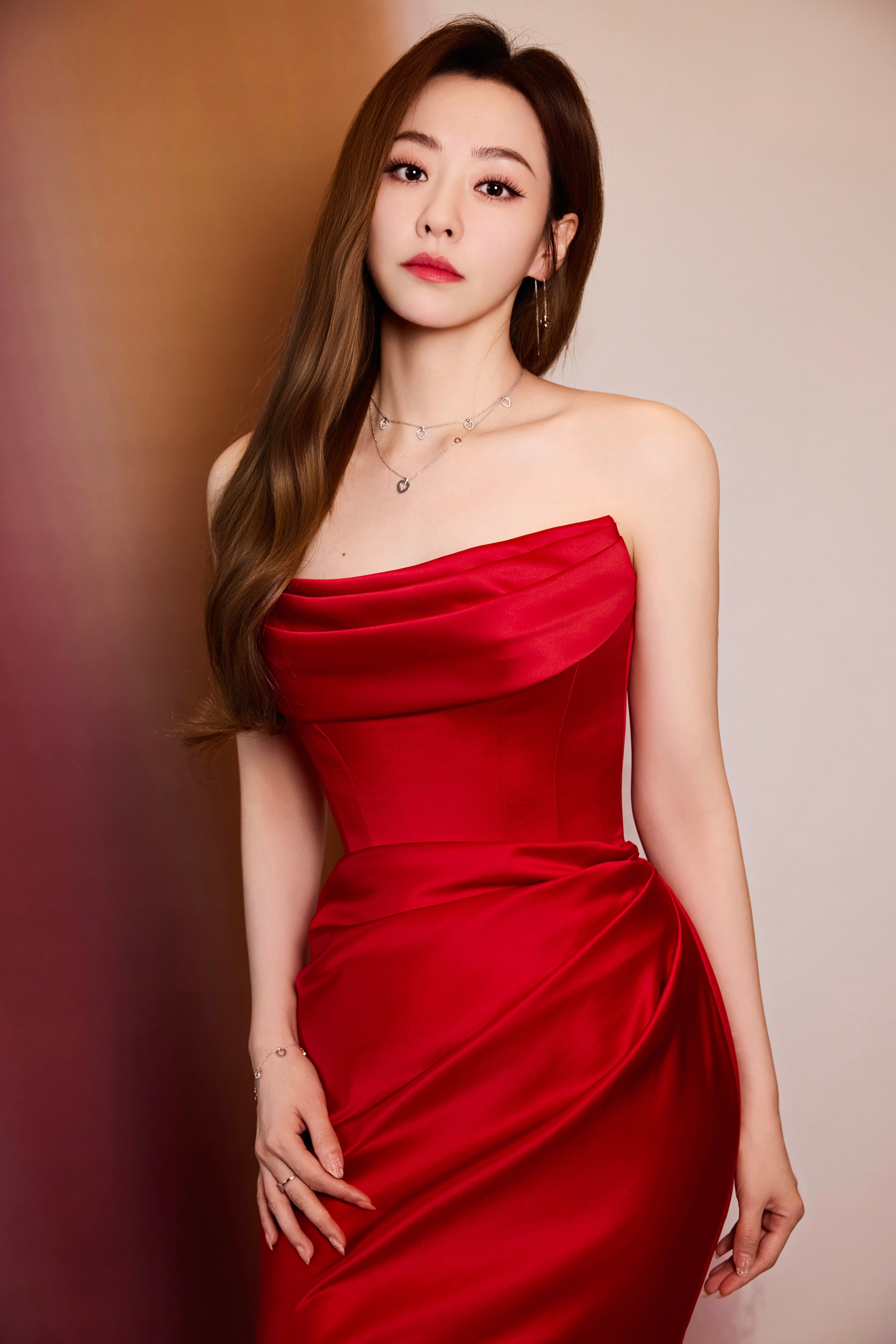 张靓颖一袭正红缎面鱼尾礼裙，抹胸设计衬得肩颈线条优雅，褶皱细节添了几分灵动，如