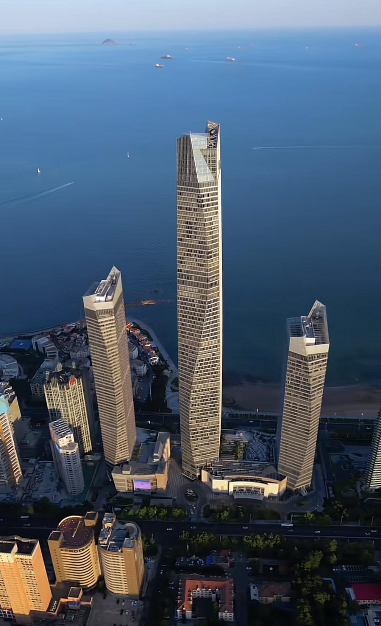 航拍青岛香港路，现代都市与碧海蓝天交相辉映。摩天大楼鳞次栉比，玻璃幕墙折射璀璨