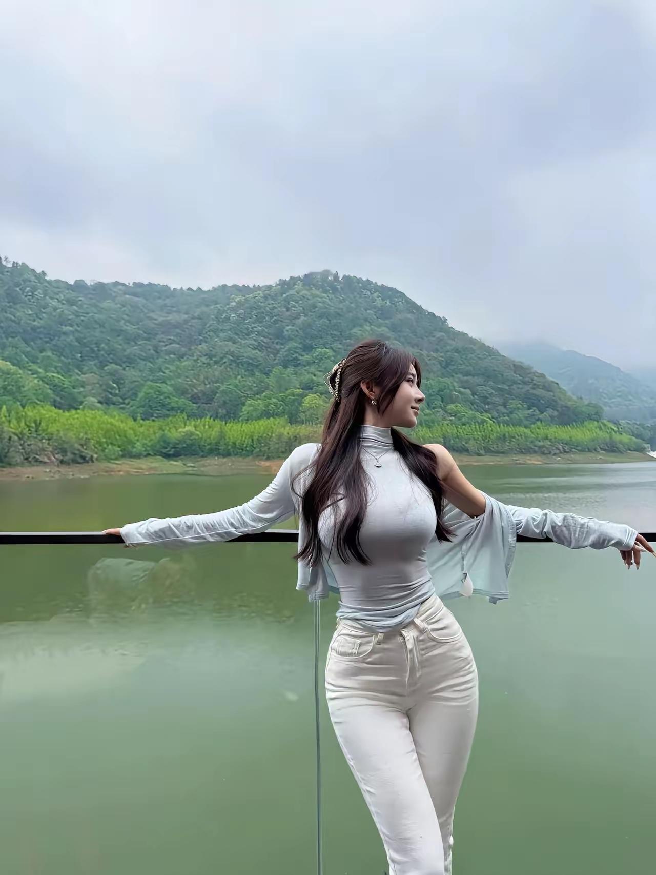 这青山绿水看着就清爽舒服，看得我都想去这种好地方玩了，小姐姐这身浅衣服既干净又显