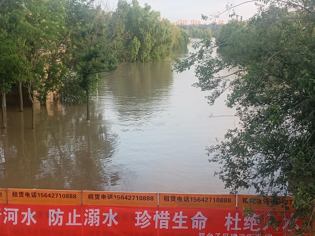 辽河涨水阔清波，长桥游人驻足多。凭栏尽览川流景，晚风伴看水天和。连日雨