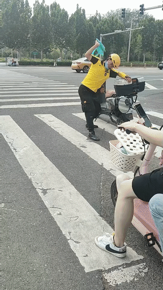 一名外卖小哥在十字路口等红灯的时候，接了一个电话。他听完电话之后突然情绪失控！