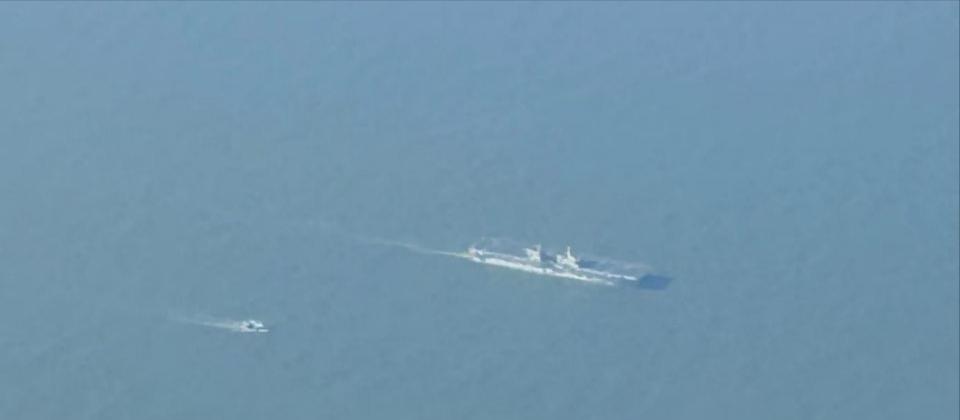 正在进行首次海试的“四川”号两栖攻击舰，旁边还有艘伴随的小船，舰艉拖着长长的尾流