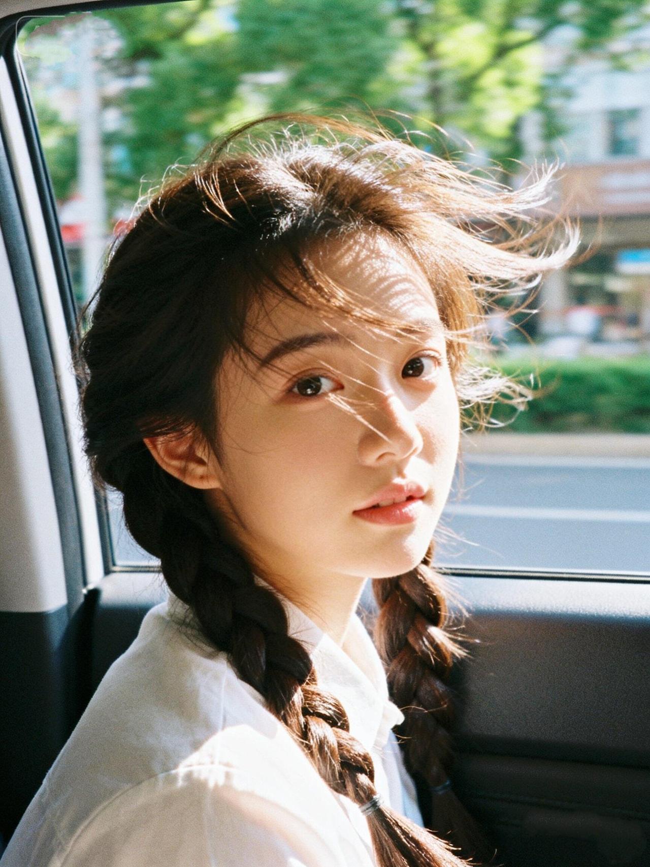 阳光洒进车窗，少女辫辫飘逸，车外绿意盎然，心情也跟着飞扬。🌞💐🚗