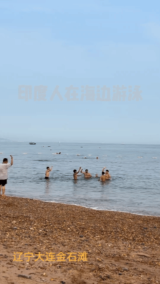 辽宁大连的一个海滩上。有当地网友拍到几个印度人站在海水里载歌载舞，大喊大叫！