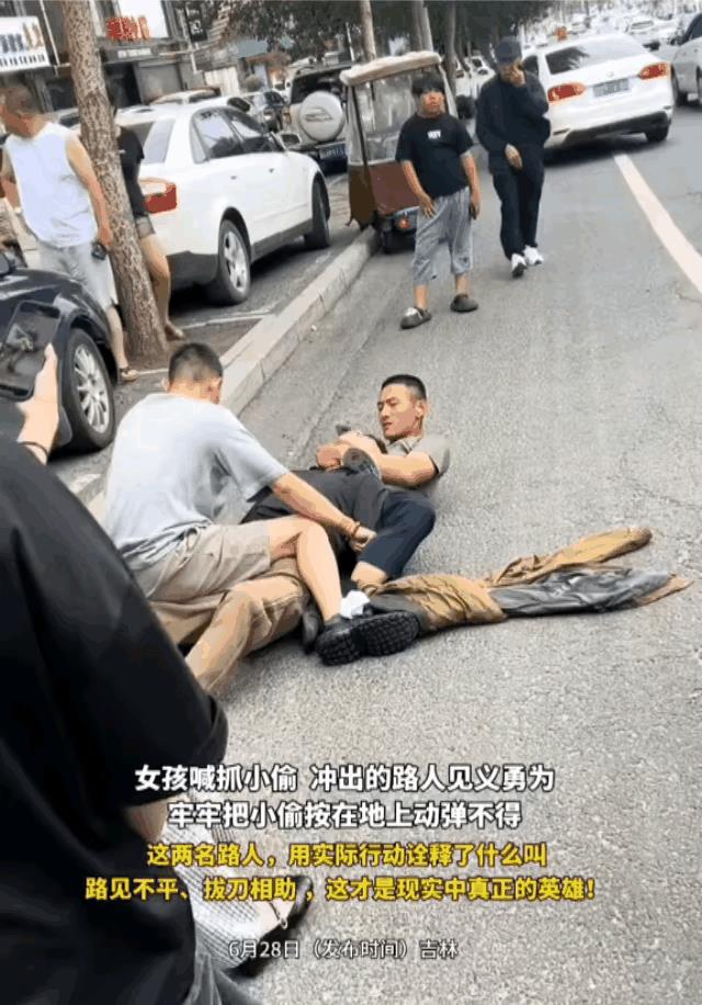 这哥们见义勇为抓住了小偷，当完全把小偷控制住之后，居然忙里偷闲，刷起了手机，这不