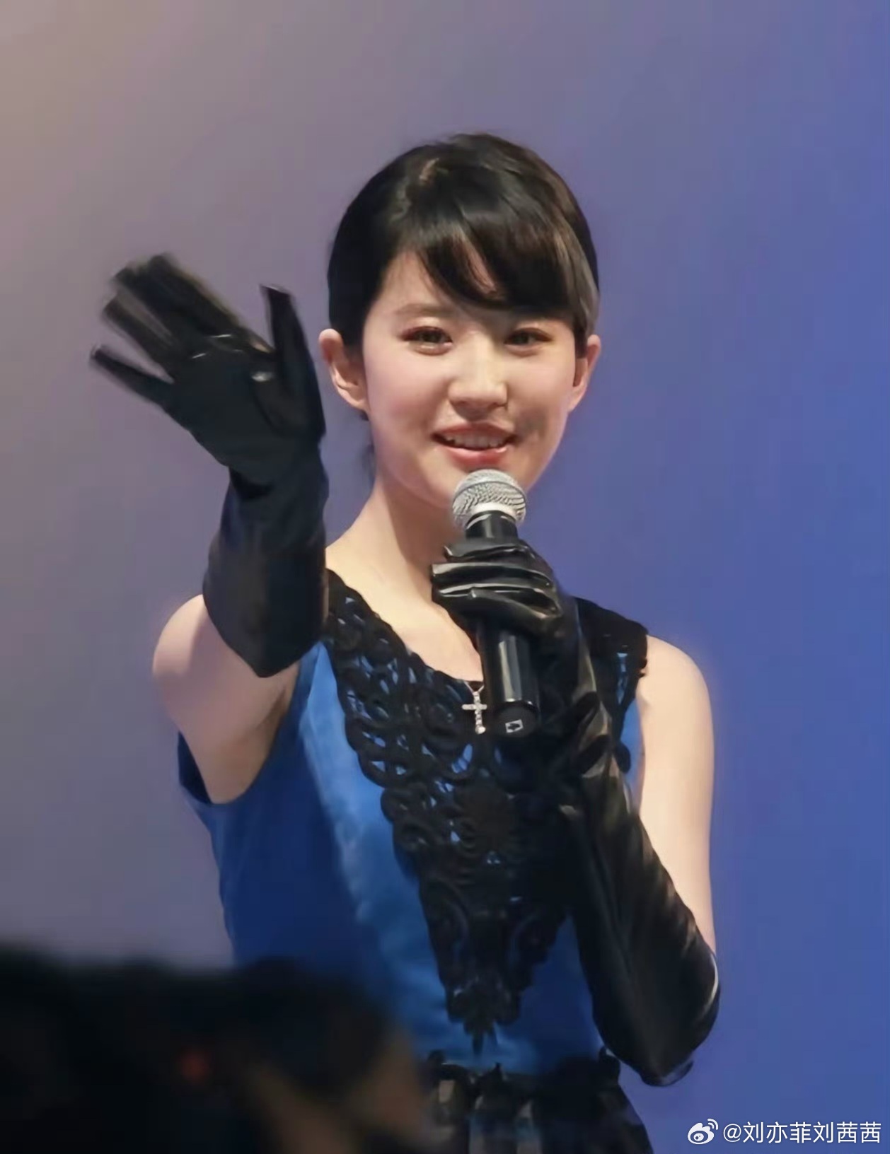 刘亦菲身穿一件宝蓝色无袖拼接裙装，上半身是亮面宝蓝色面料，搭配黑色立体蕾丝雕花，
