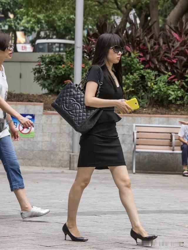 都市时尚女郎，黑裙配高跟鞋，自信走在街头