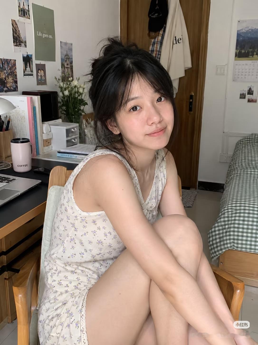 女孩坐在书桌前，微笑看着镜头。
