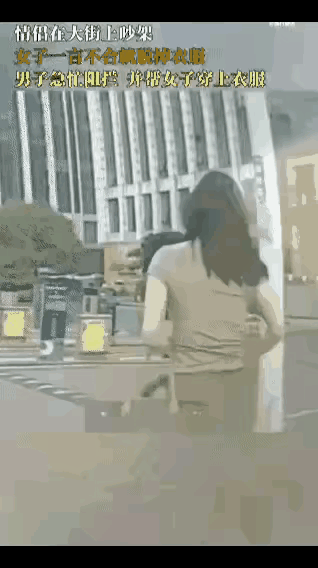 大街上一对情侣吵架，女子一言不合就脱上衣还想解胸罩，男友慌忙抱住她帮穿好衣服，可