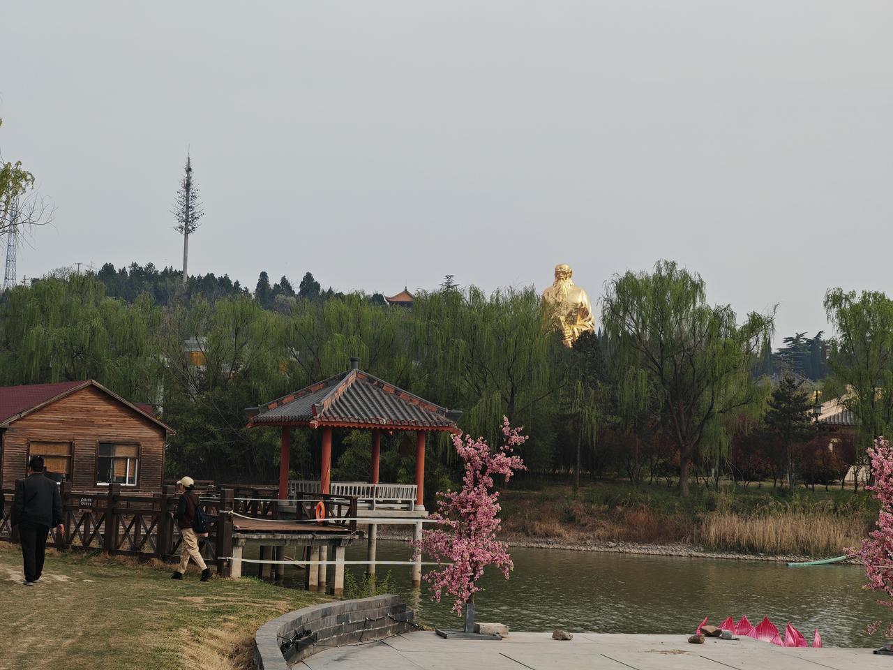你眼中的古镇是什么样的这张图片展现了春日公园的一角。湖边，木亭与小屋临水而立，柳