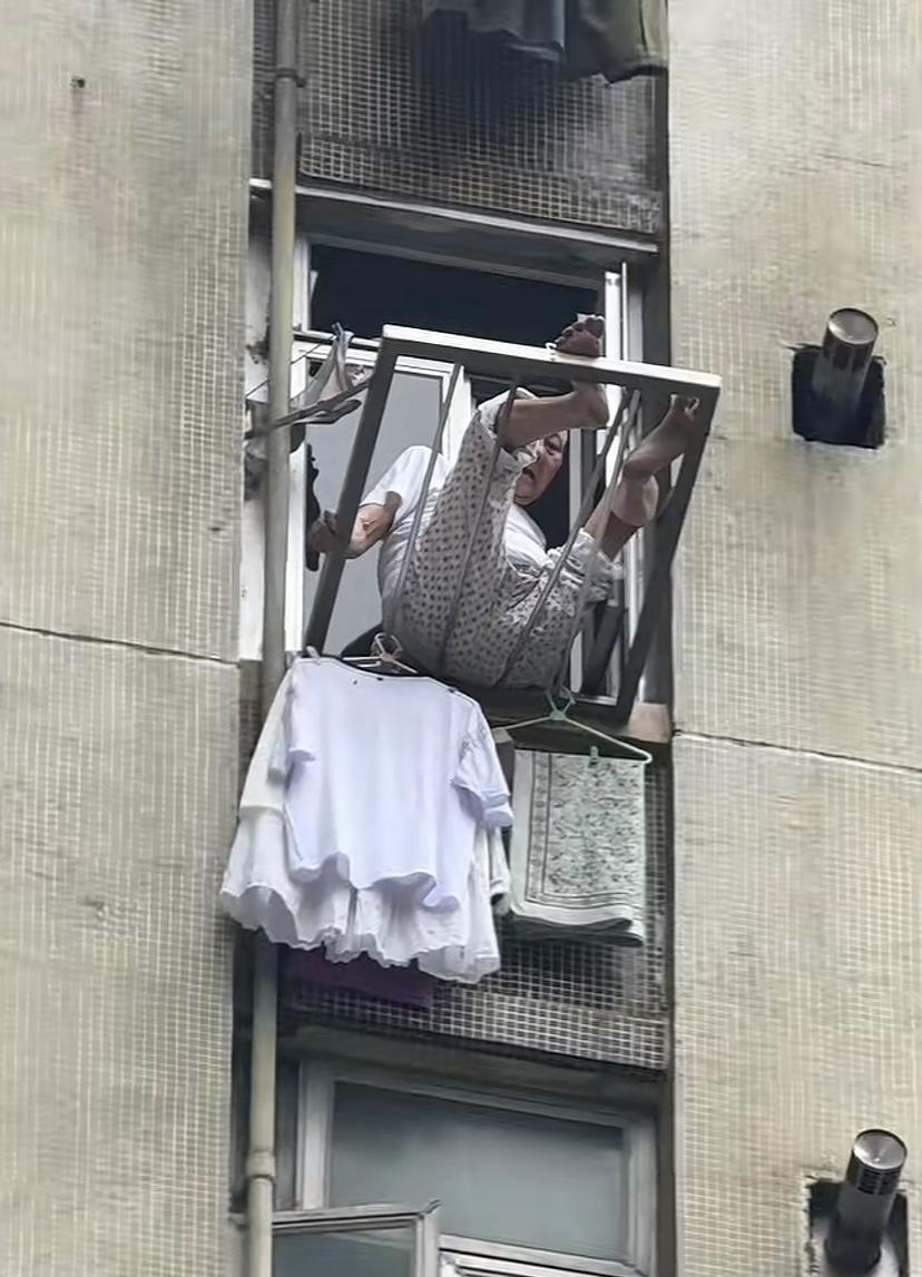 5月19日（发布）香港一高楼住宅高层处，1名老人爬出窗户外坐在晾衣服的不锈钢架上