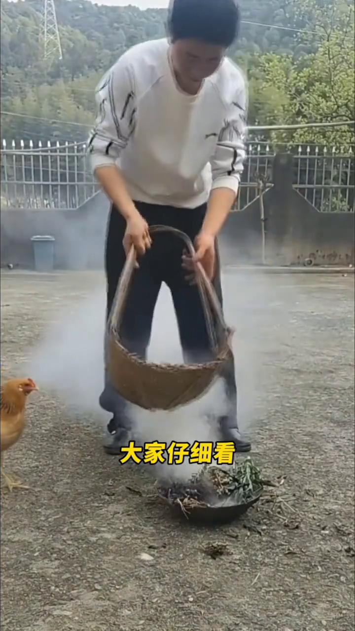 大家仔细看，这位男子刚把小鸡买回家，就点燃一堆干草架在篮子下方，用袅袅升起的浓烟