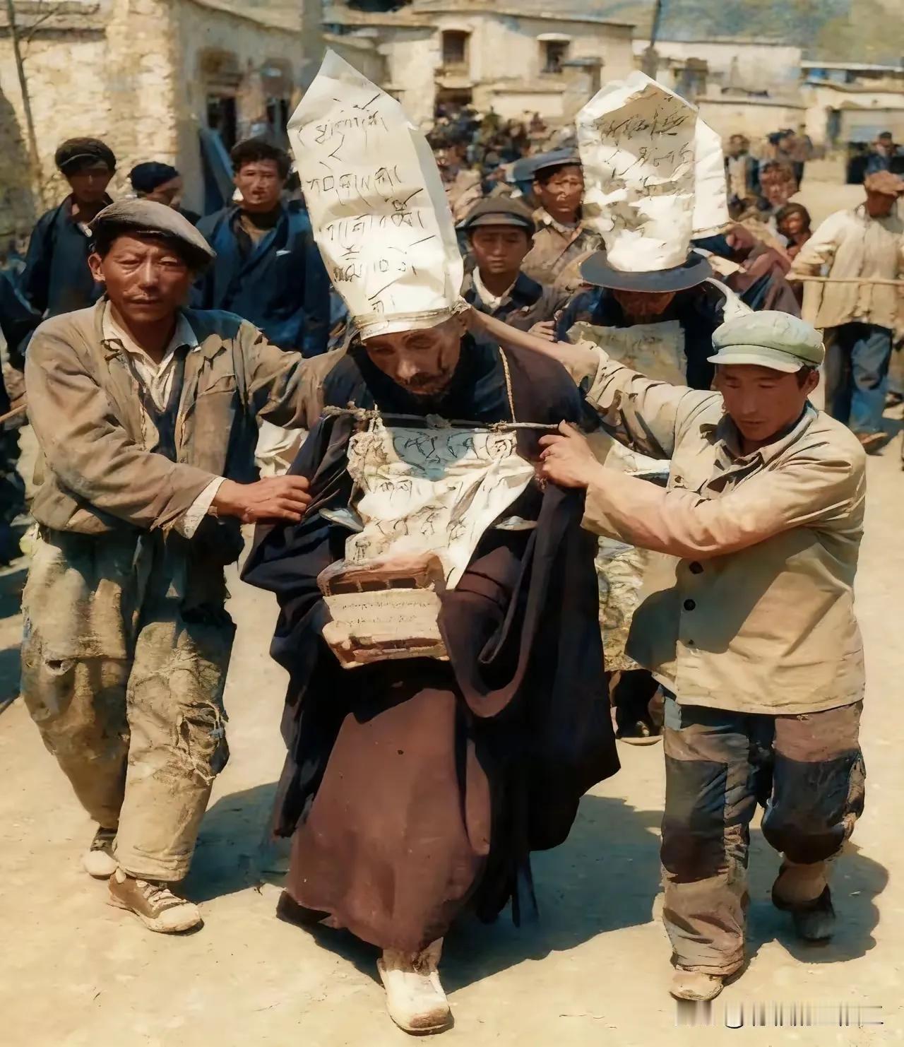 “革命不是请客吃饭”！上个世纪六十年代，西藏拉萨市街头，奴隶主头戴尖纸帽、挂犯由