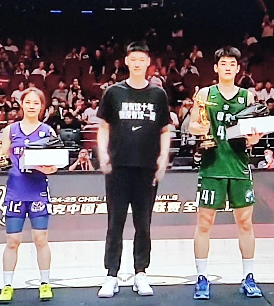 胡金秋给获得耐高冠军的高中生球员颁MVP奖杯，从画面来看，广东省实的王洪泽跟胡金