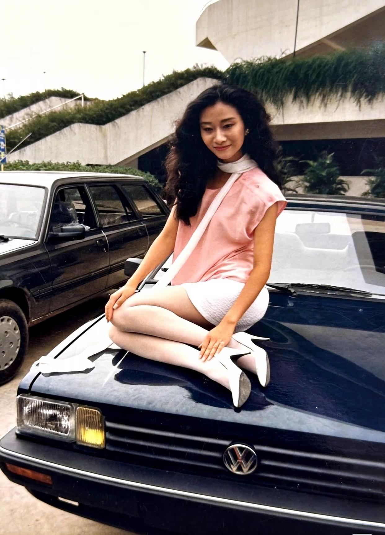 上个世纪90年代，坐在桑塔纳上的车模。那时候的桑塔纳一辆车出厂价都要十几万，落地
