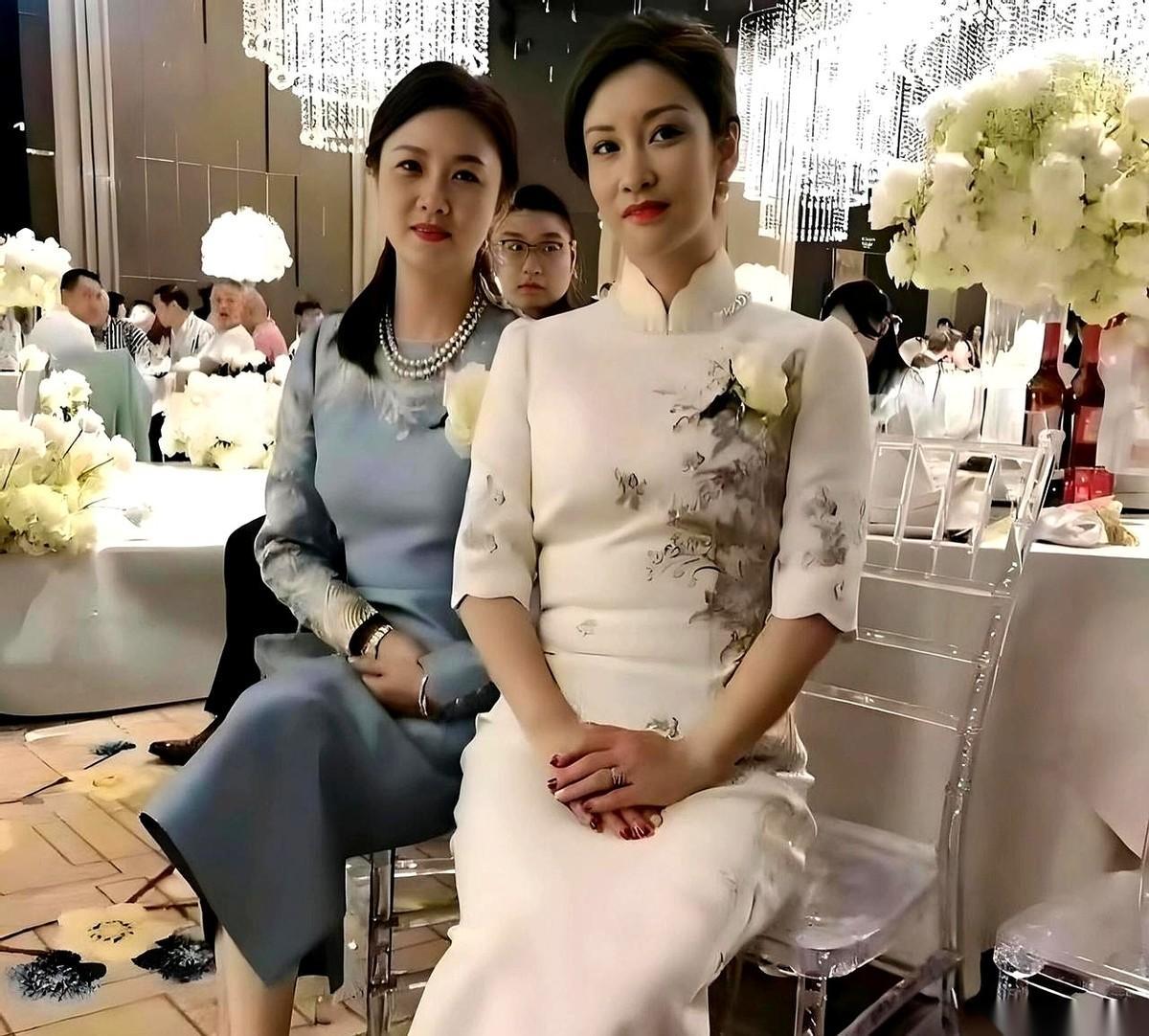 就这张两个亲家母碰头的照片，我来回放大了三遍。左边这位，一身翡翠绿，手腕上那只