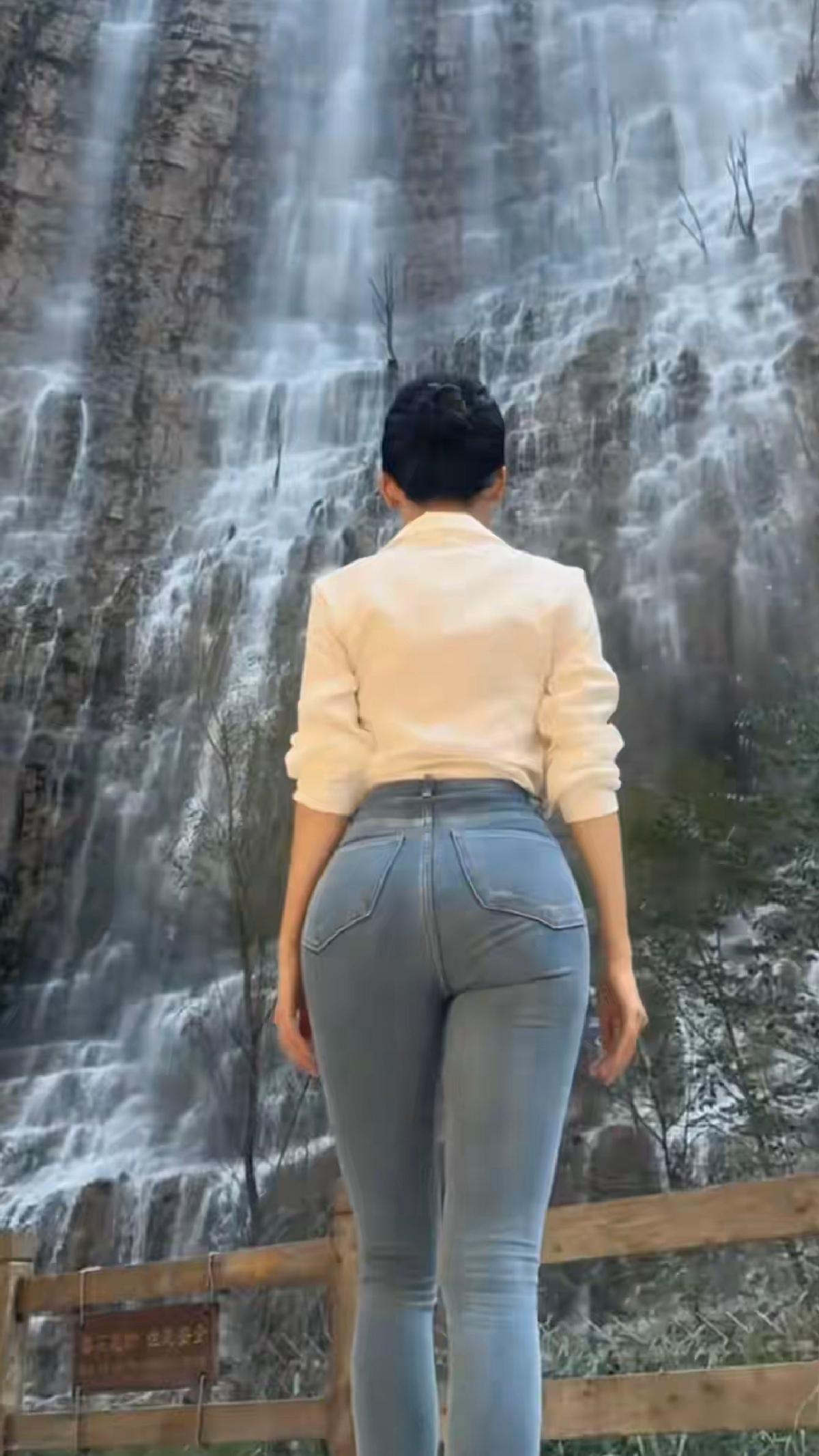 一个身材很好的美女站在瀑布前，背对着镜头，好看吗？