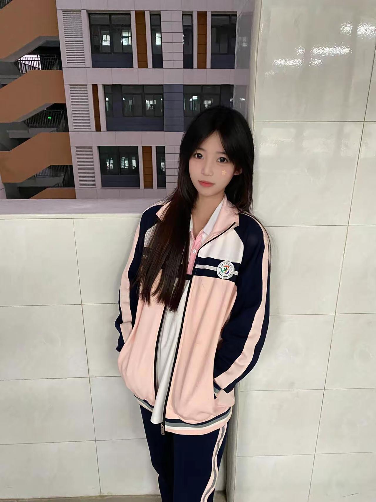 这姑娘穿校服站在墙边。青涩校服少女校园里的小女孩绿衣少女