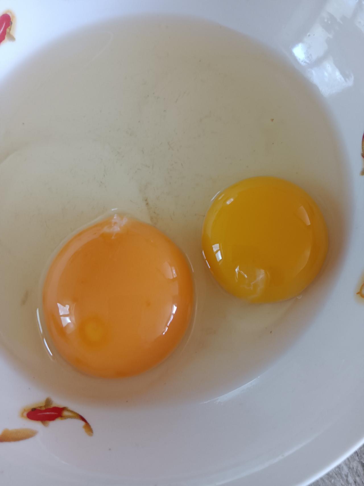 这两个都是鸡蛋黄你们看看有啥不同？一个是散养的笨鸡蛋一个是养殖鸡蛋这颜色
