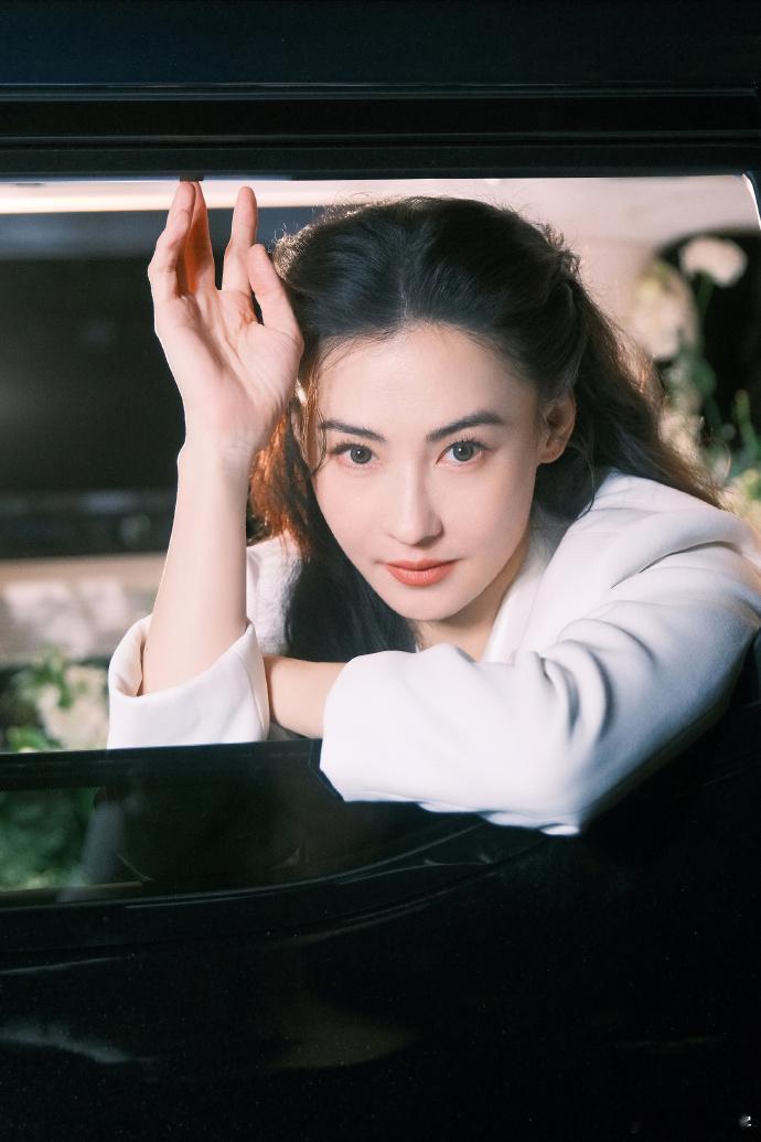 张柏芝身着白色西装，立于花海，优雅酷飒。顶级骨相，轮廓流畅，岁月流转，她始终美得