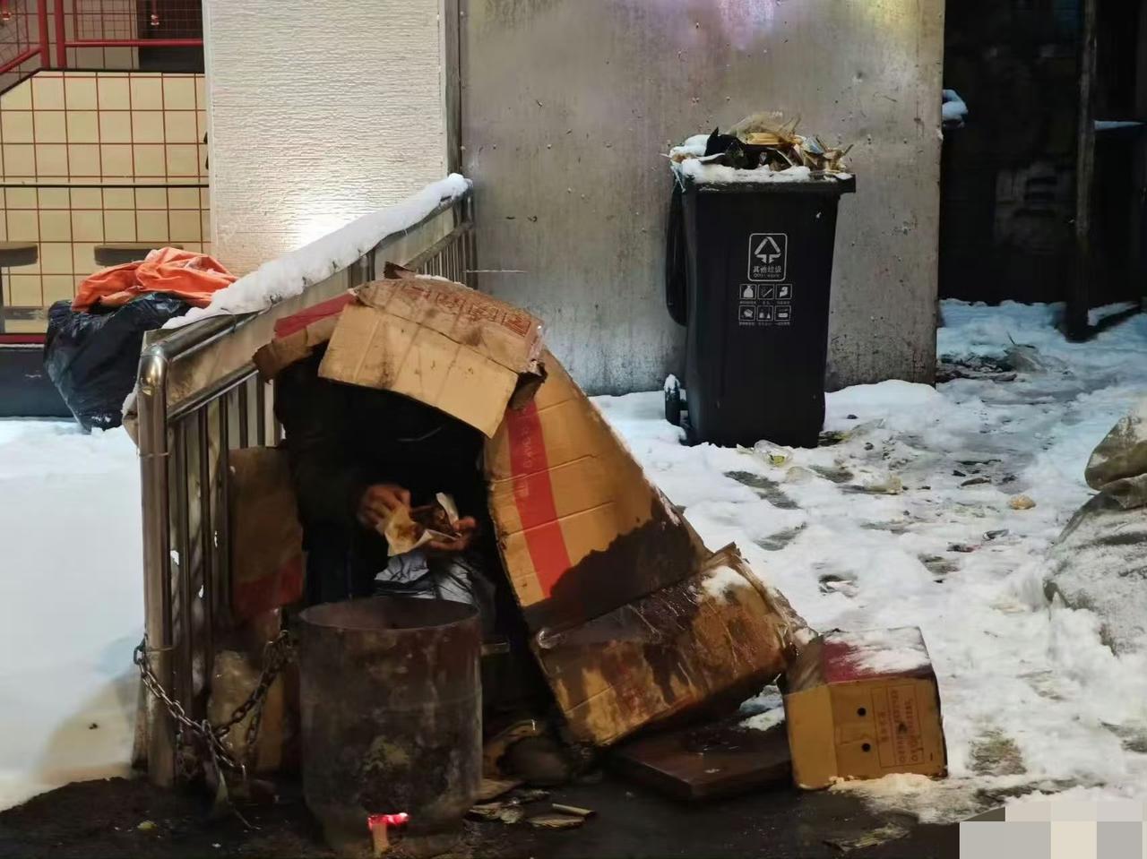 沈阳网友爆料，一垃圾桶旁边发现露宿者，零下十几度的低温，就靠外面搭了一个简易的纸