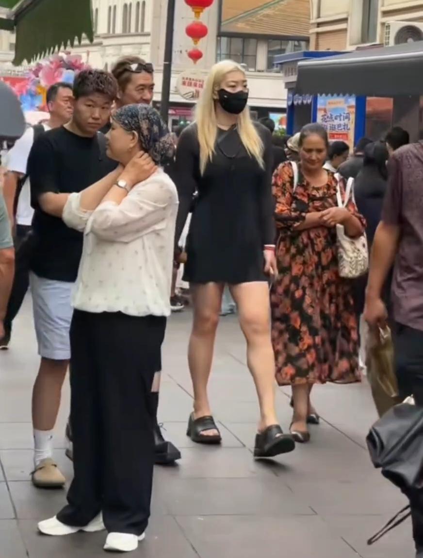 形同路人！近日中国女篮原队员李梦，现身新疆乌鲁木齐大巴扎，虽然身材高大，一头金发