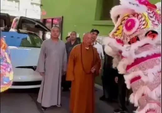 释永信和特斯拉ModelX合影！照片中释永信和一名穿灰袍的僧人站在一辆打开鸥