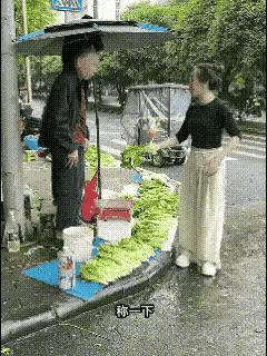 是无商不精，还是无商不“奸”？街边小菜摊上，大爷撑着雨伞在卖菜，一位美女顾客