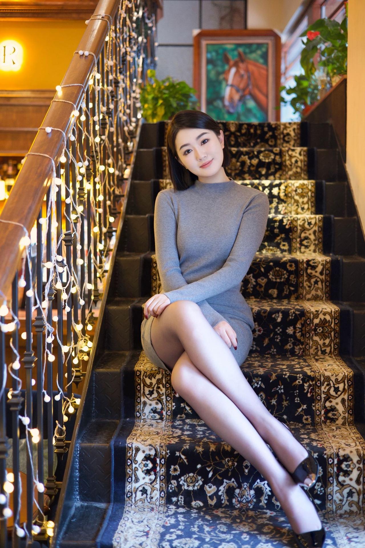 优雅坐楼梯，暖灯映笑颜