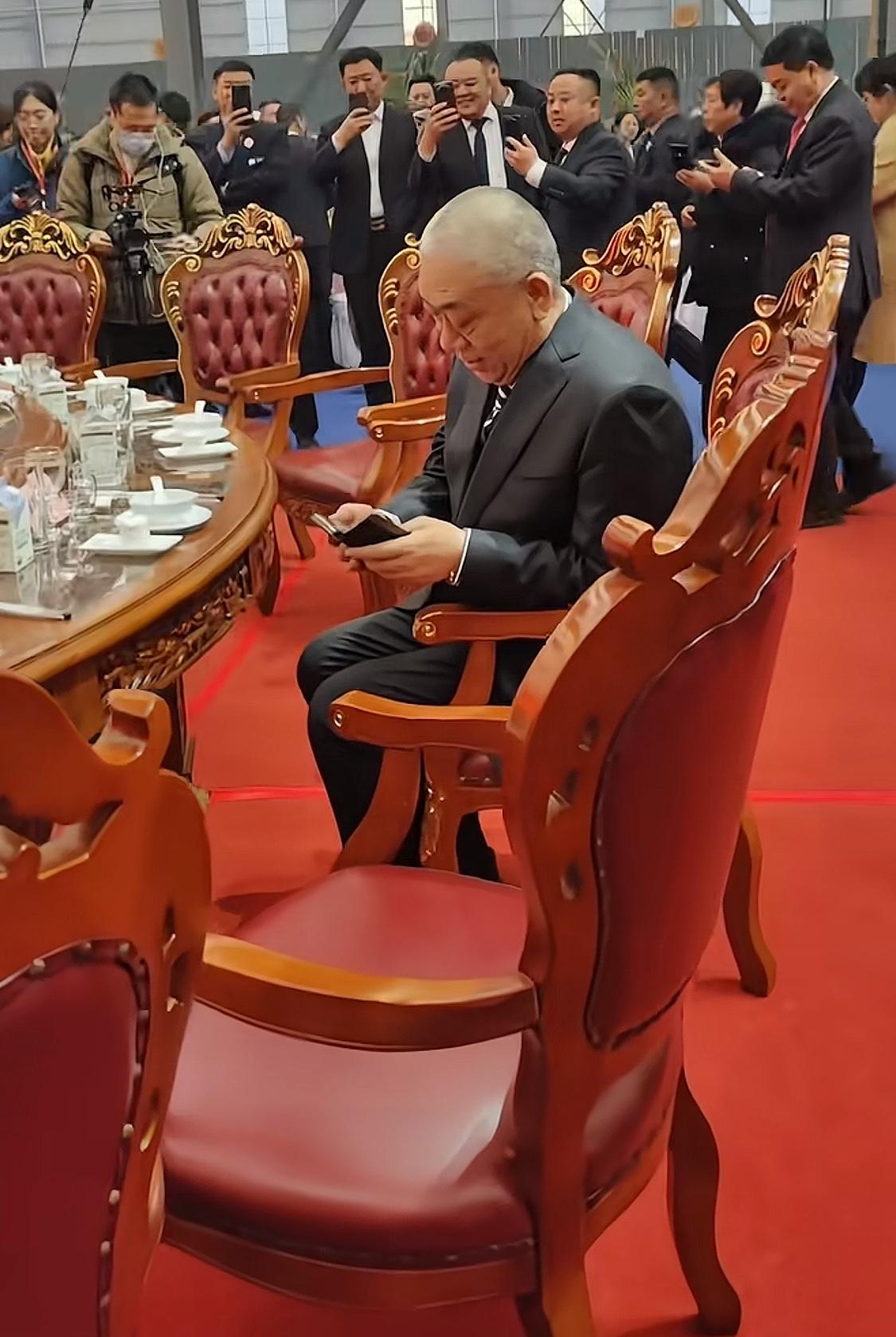 崔培军在活动上的一幕，周围都是拿着手机拍照的人。