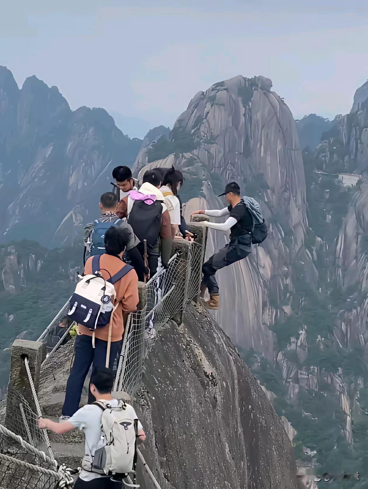 山顶之巅，窄窄的过道，人群拥挤，一游客翻身围栏之外，这么多不安全的因素，景区挤人