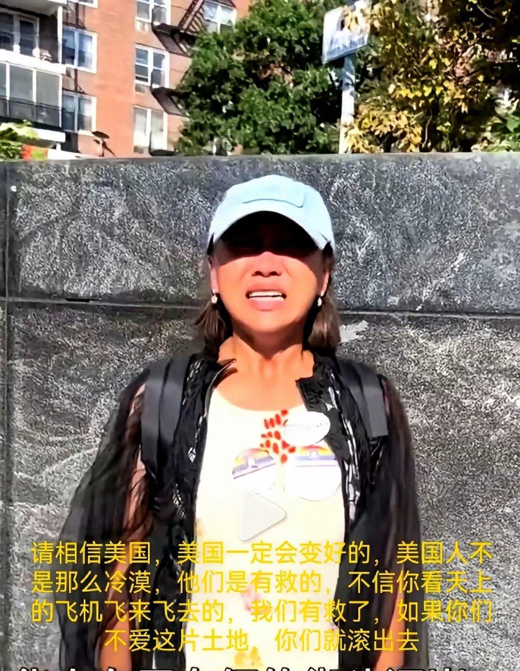 美国纽约街头，近日一名华人女子，戴着帽子，举着纸板，崩溃哭喊：相信美国，会好起来