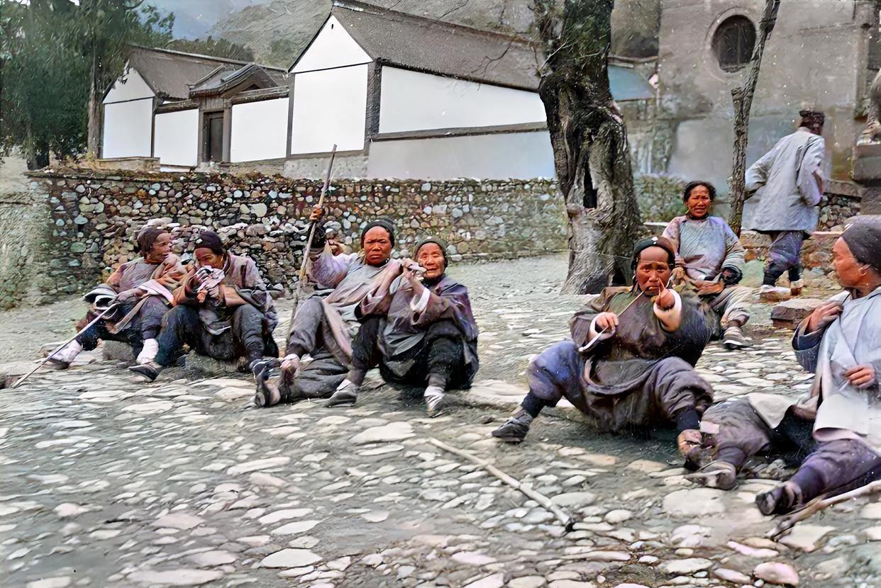 老照片欣赏几个小脚老太太抽着大烟，坐在大树下聊天，脚不大烟袋杆还挺长，当时她们