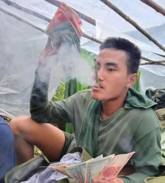 挥舞百元大钞的若开军士兵！这些缅北地区的若开军士兵，嘴里吞云吐雾，手里有大量