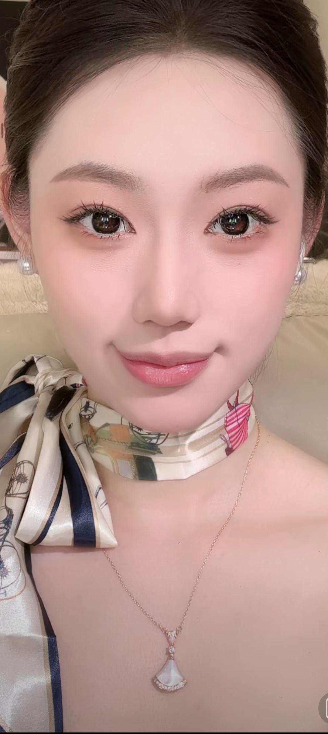 这位美女戴着珍珠项链，看着镜头微笑。