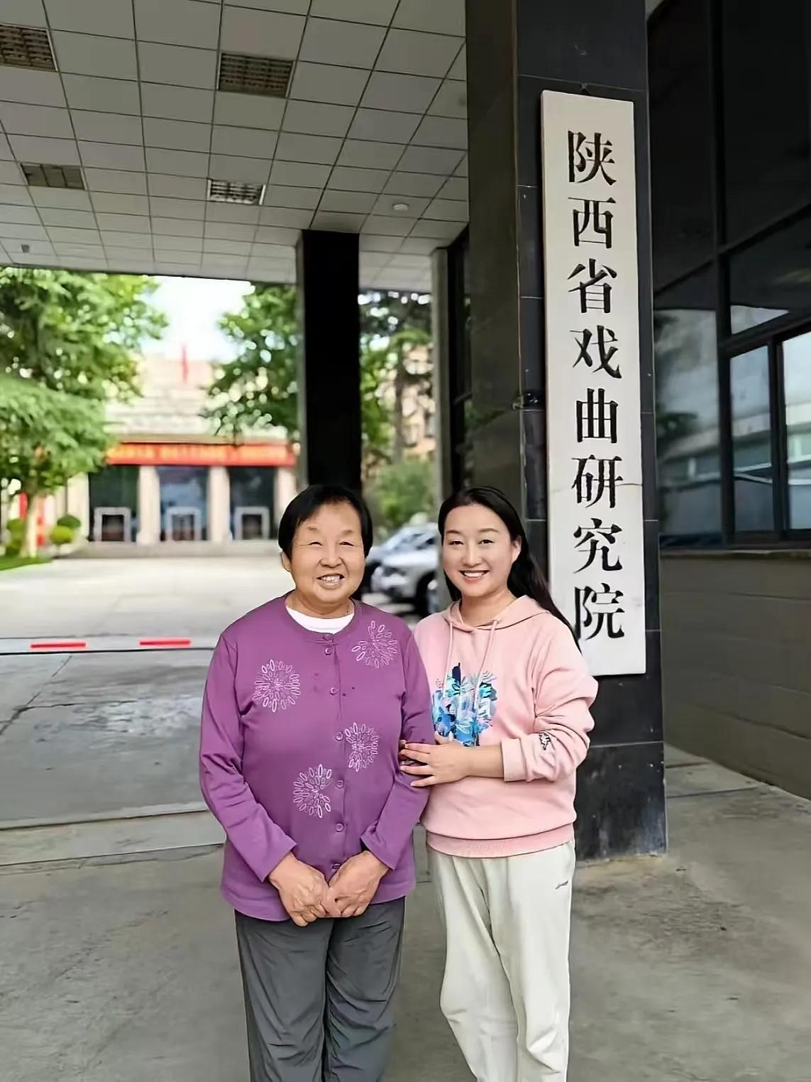 上世纪九十年代，一位母亲和女儿在陕西戏曲研究院大门前的一张合影。当时女儿在该