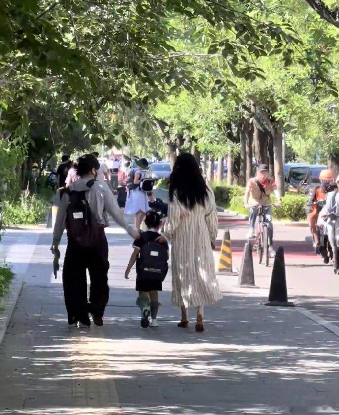 三里屯偶遇朱珠接孩子放学三里屯街头抓拍路透，朱珠简单一条条纹长裙气质出众，专心
