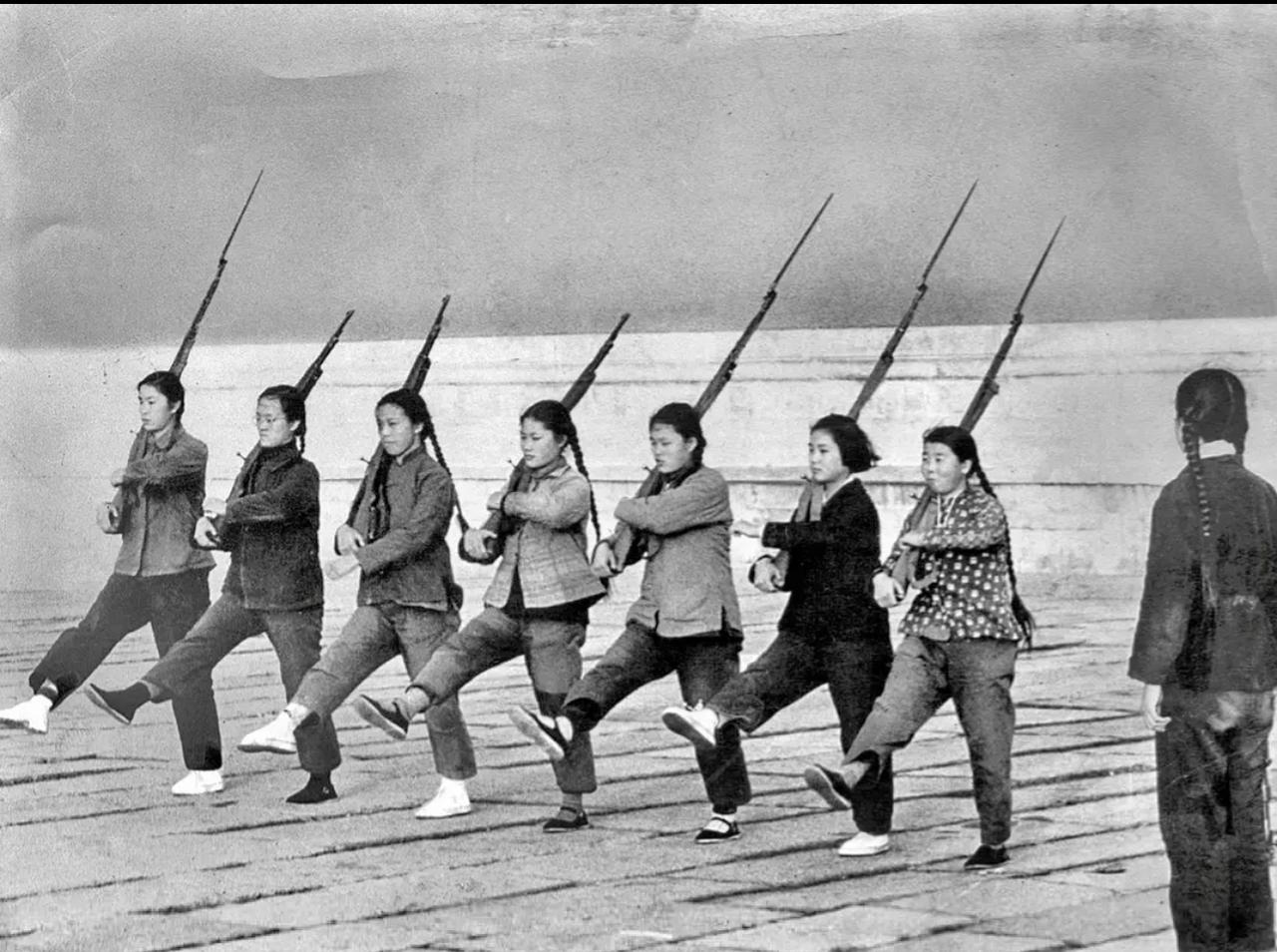 1966年，几位女民兵正在北京故宫旁边训练。几个姑娘扛着步枪练习踢正步，表情
