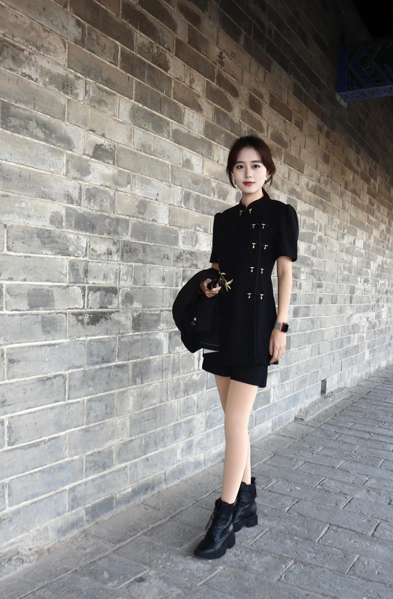 黑色改良旗袍式上衣，金色盘扣精致亮眼，凸显出优雅与复古的气质，搭配同色系短裤，简