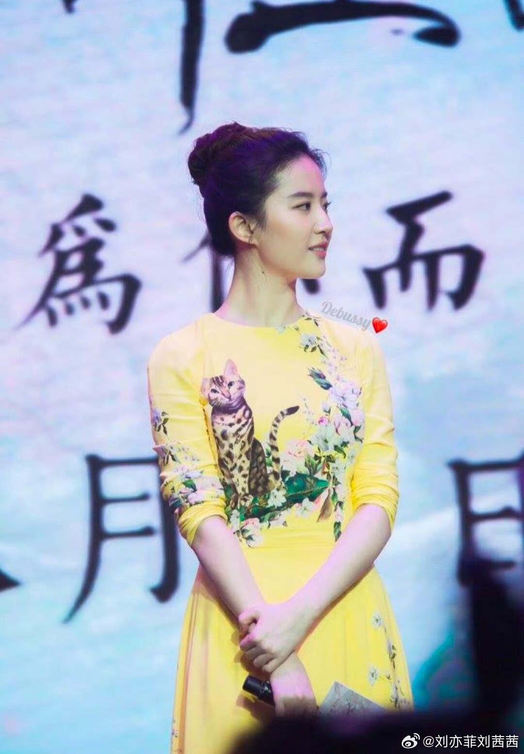刘亦菲此次选择的明黄色收腰连衣裙，高饱和度的色彩明媚又吸睛，完美衬托出她白皙的肌