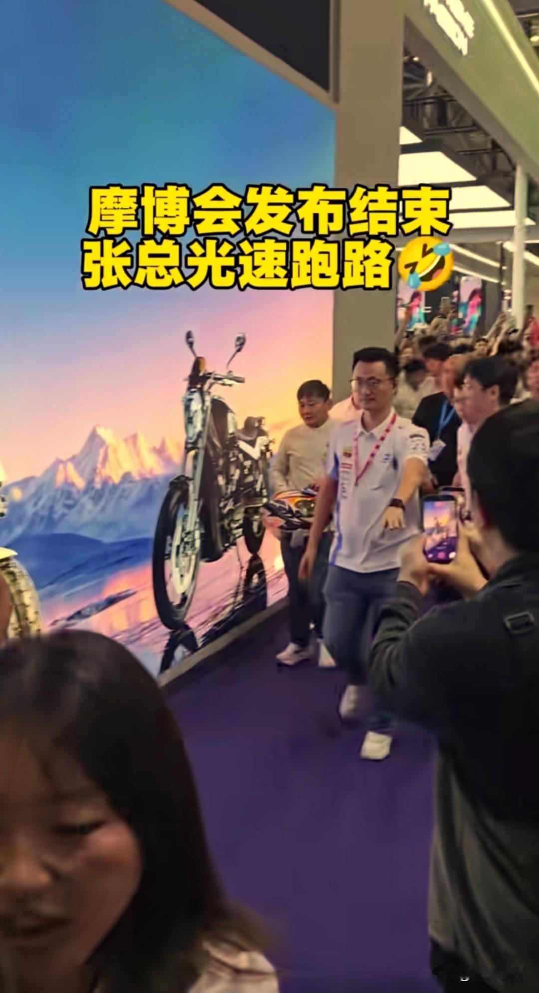 重庆摩博会发布会刚结束，张雪就在工作人员护送下快步离场。一出展厅，他小跑着戴上头