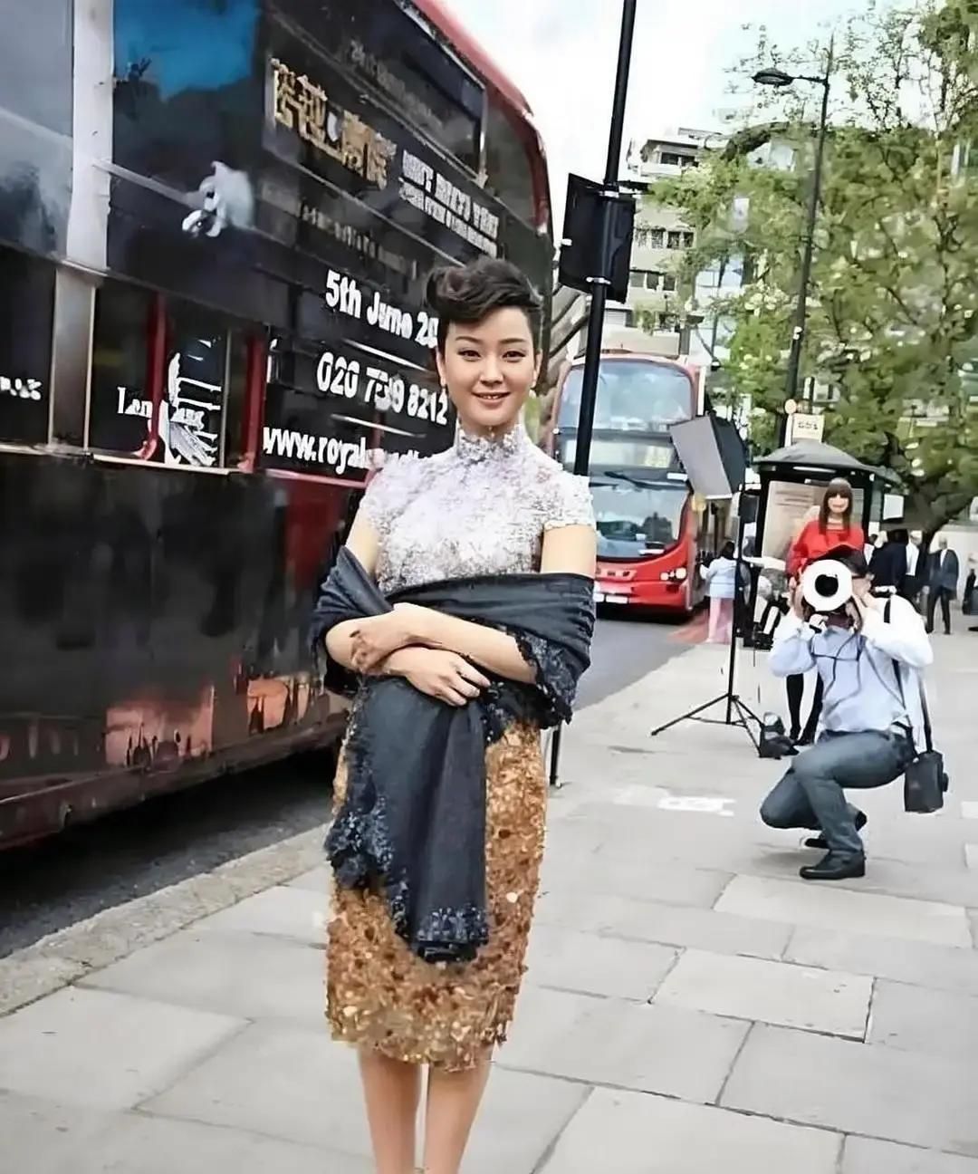 宋祖英在伦敦街头被拍到，淡青刺绣旗袍配开衫，头发一丝不乱，冲路人点头微笑，58岁