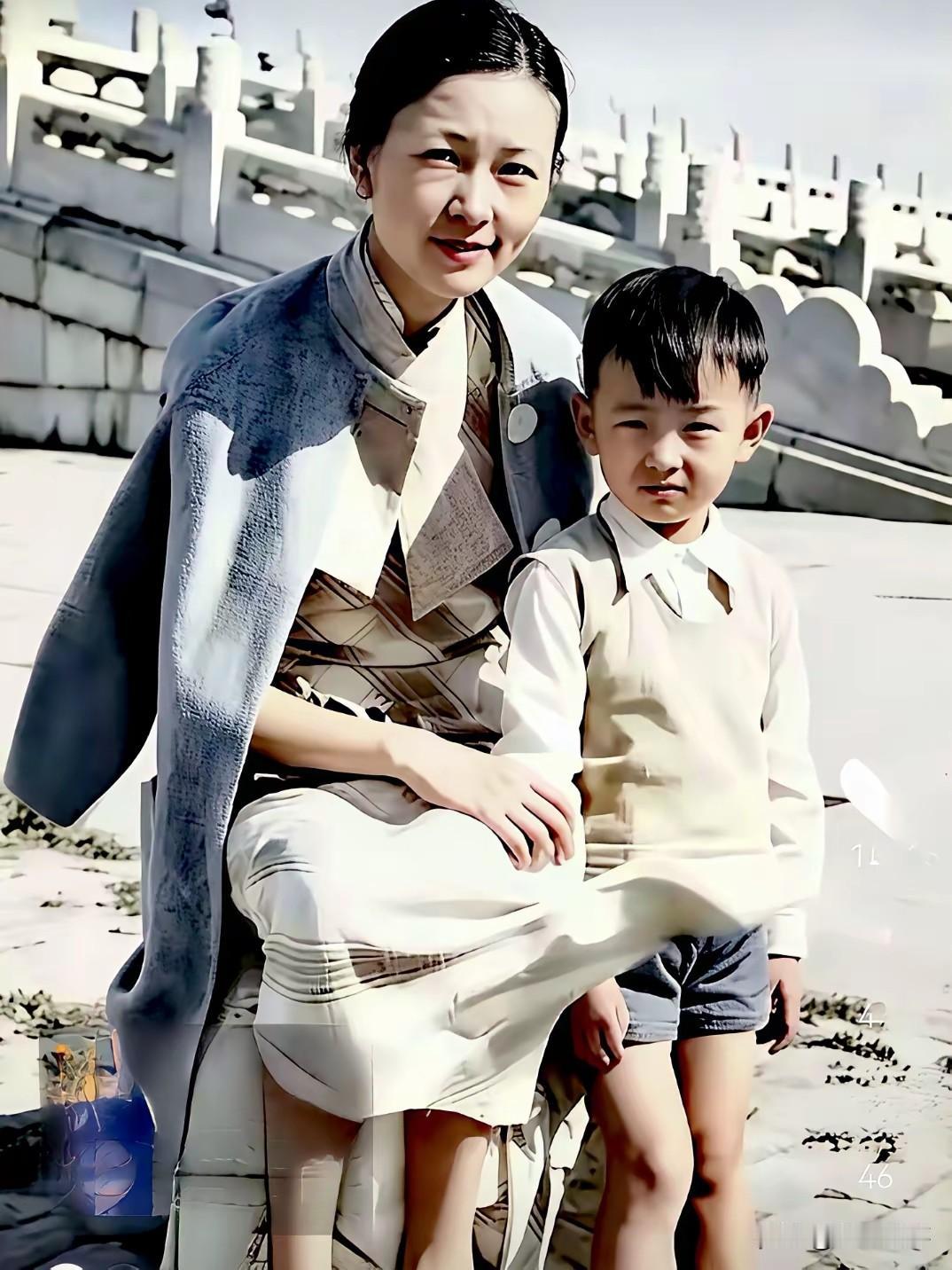 1936年故，宫门前，32岁的林徽因怀抱孩子，端坐于宫墙之前。镜头下，她一身剪裁