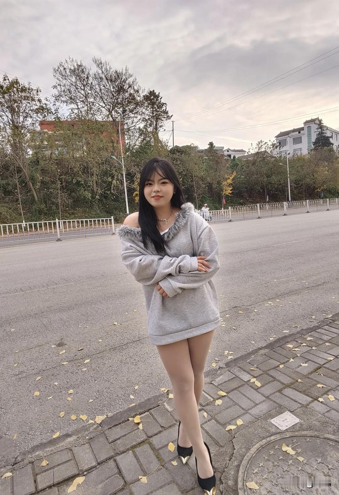 秋日街拍里，灰色毛衣搭配肉色丝袜和黑色高跟鞋，这组合简直时尚与温暖兼得。灰色毛衣