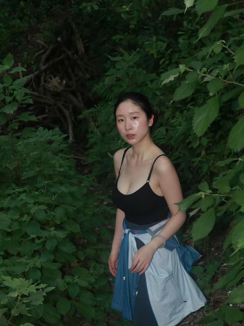 阳光钻过树叶缝儿洒下来，一身黑溜溜的紧身运动装贴得浑身利落，爬完一截山路，就着林