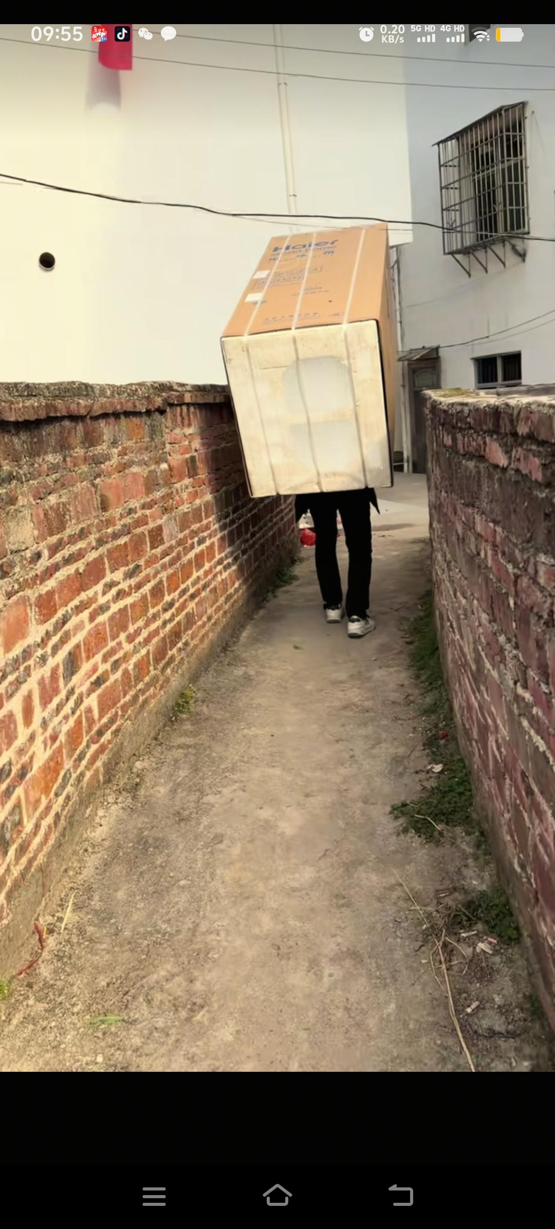 梁志辉回到江西赣州的老家，给爸爸买了一台新冰箱。他亲自把冰箱从车上卸下来，然后背