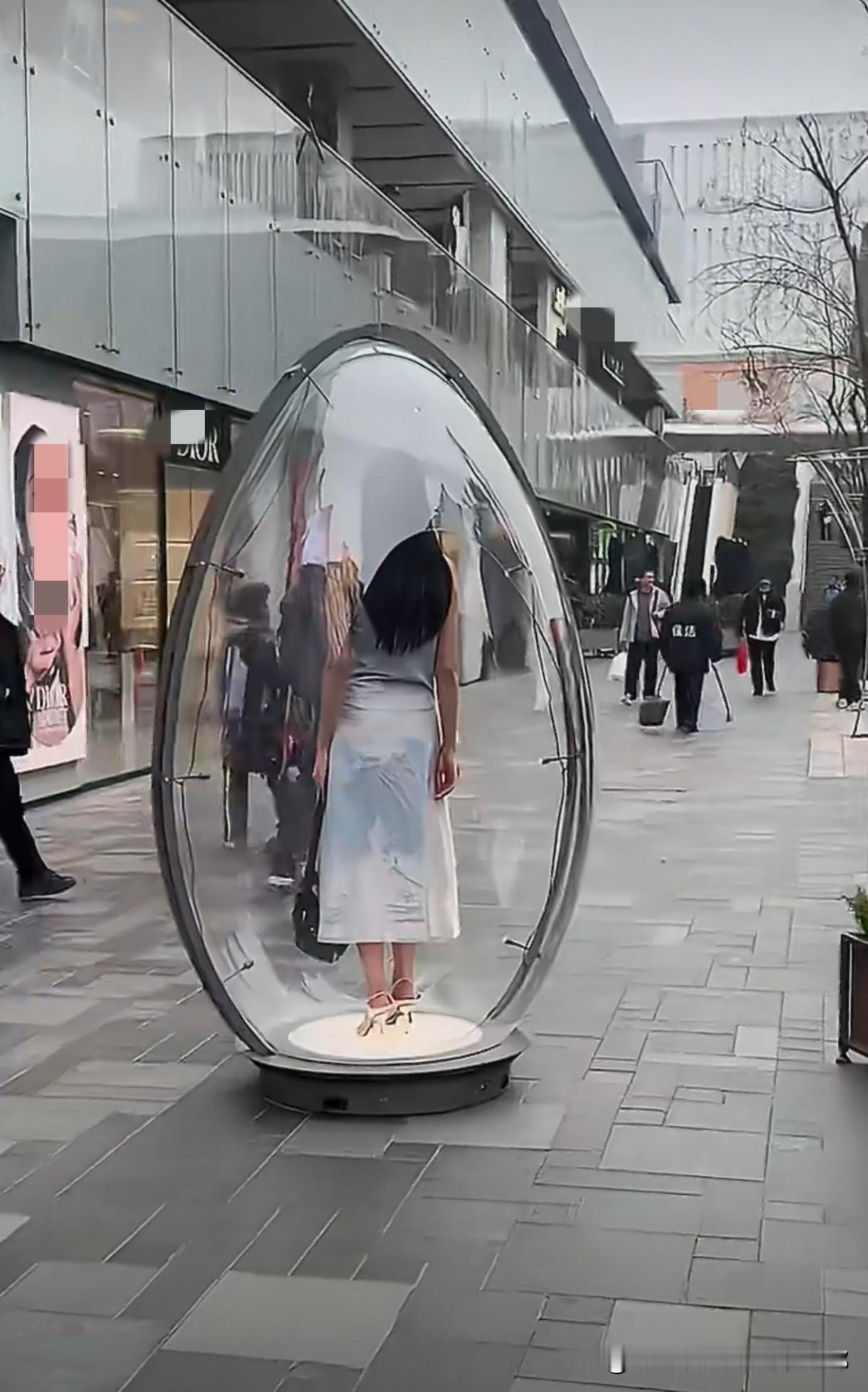 北京太古里一个大透明蛋直接摆在步行街正中间，里头站着个穿浅色长裙、高跟鞋的女生，